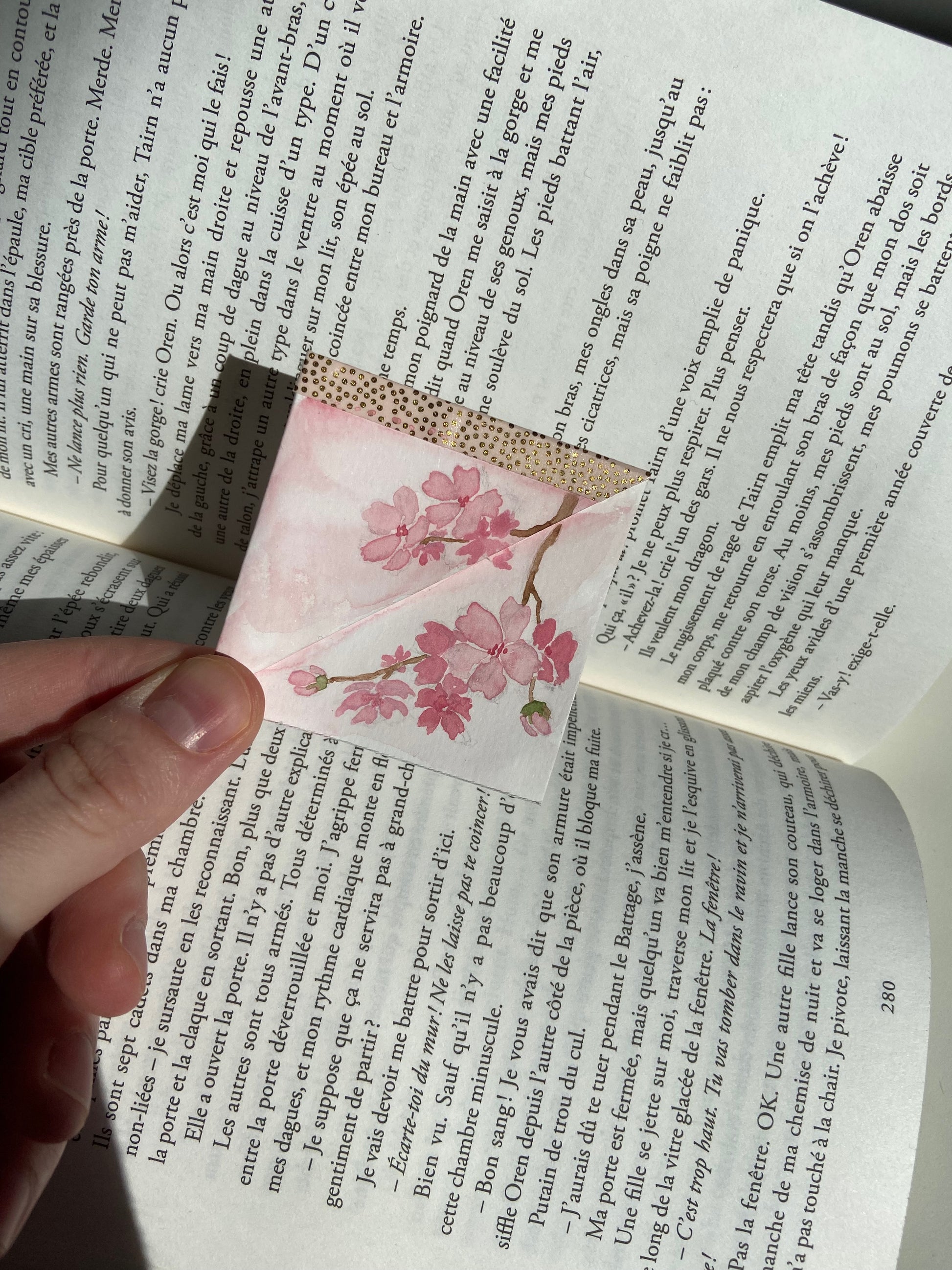 marque-page d'angle au modèle cerisier en fleurs au dessus d'un livre ouvert