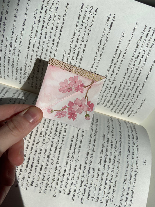 marque-page d'angle au modèle cerisier en fleurs au dessus d'un livre ouvert